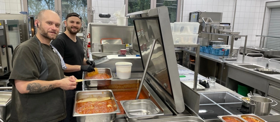 zwei Köche legen Lasagne