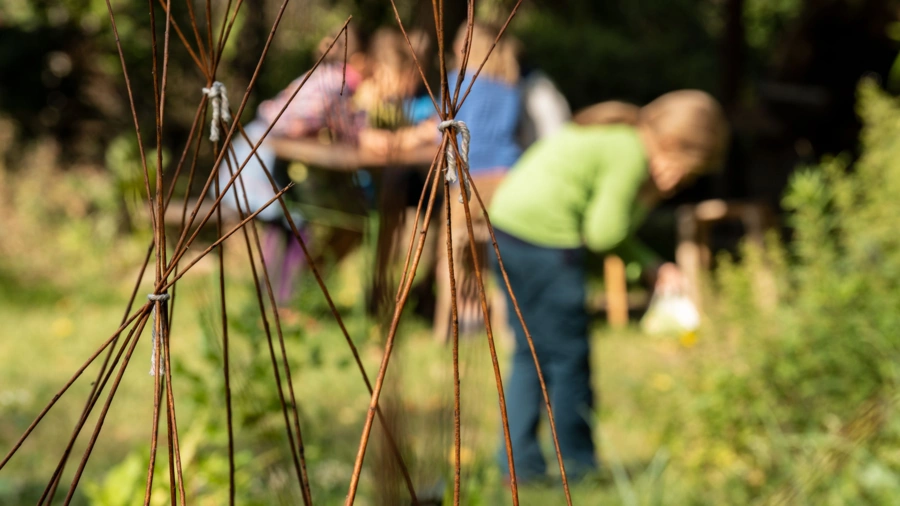 Kinder flechten Körbe im Garten